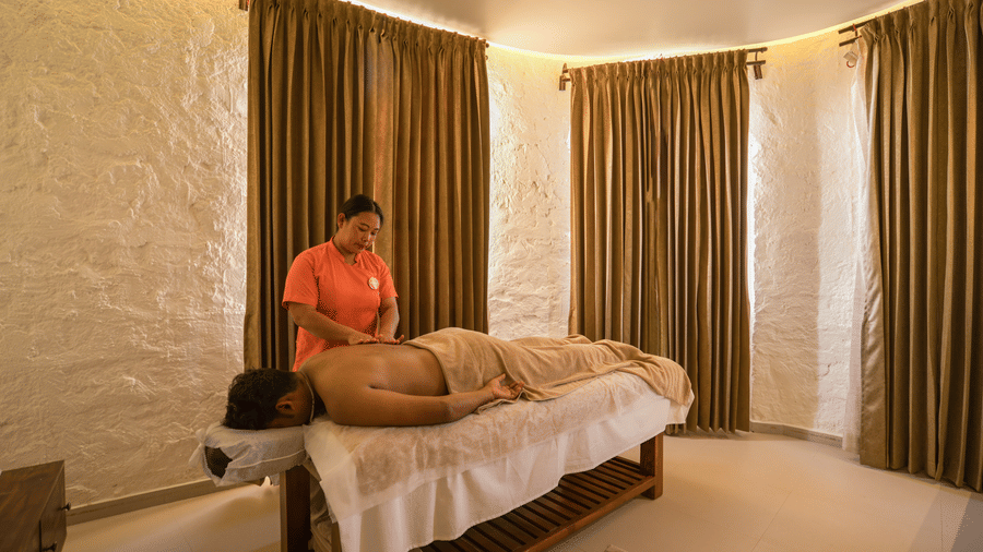  A serene spa treatment room with warm lighting and a therapist giving a massage. | Mango Hill, Yercaud