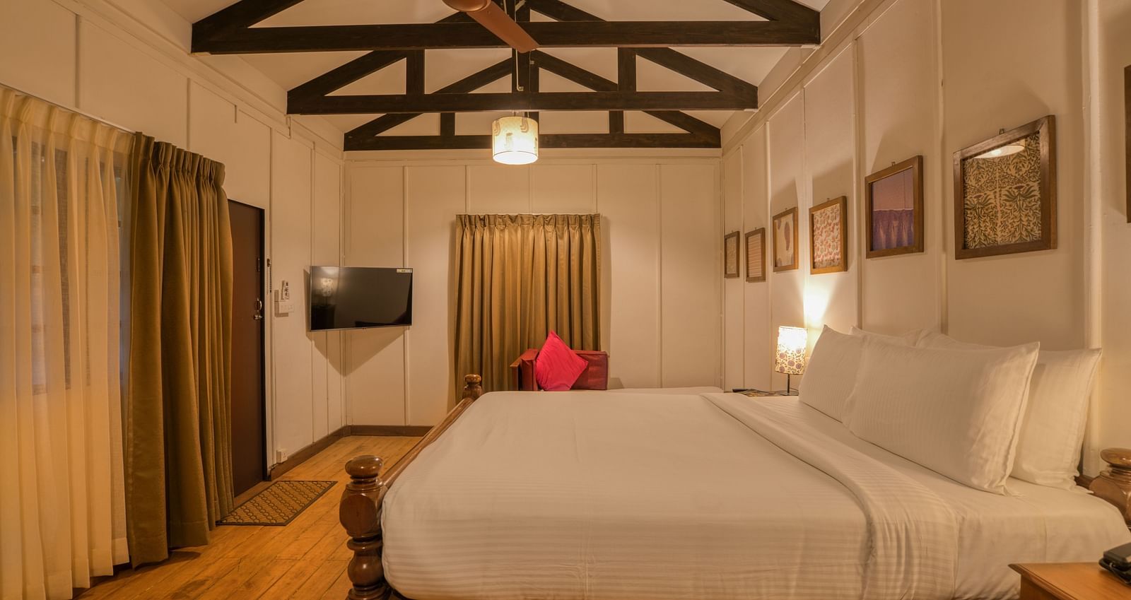 Swiss Chalet Bedroom with a bed, TV and paintings.