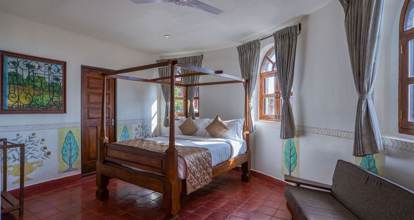 Hotel room with a four-poster bed, large windows, and rustic decor. | Mango Hill, Yercaud