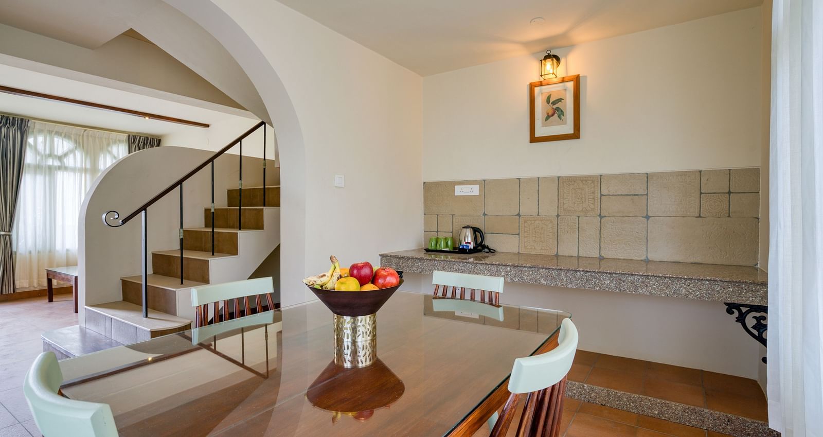 The dining area in view with a staircase on the side inside bedroom villa with a balcony | Mango Hill Shola Ooty