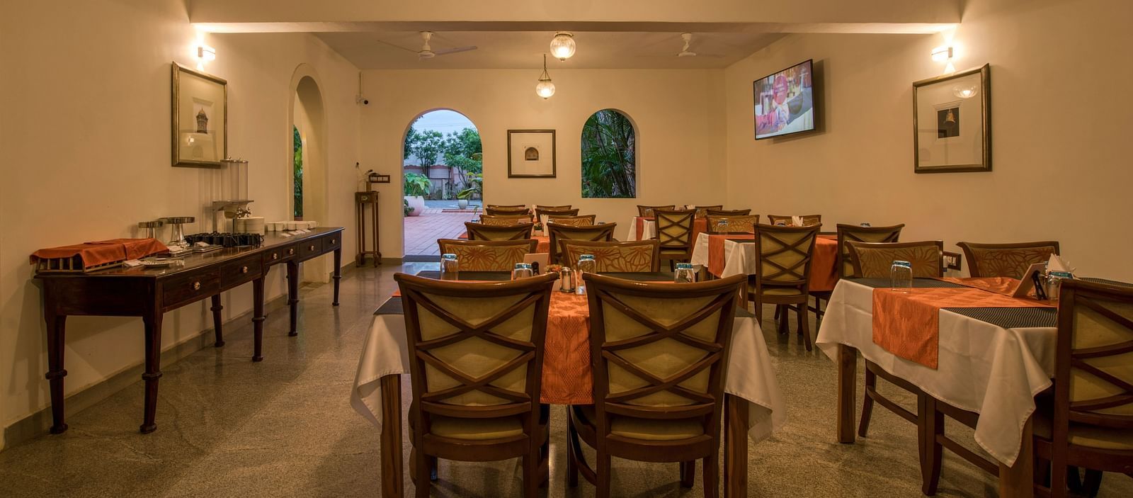 Back view of dinning space at a restaurant with chairs and tables.