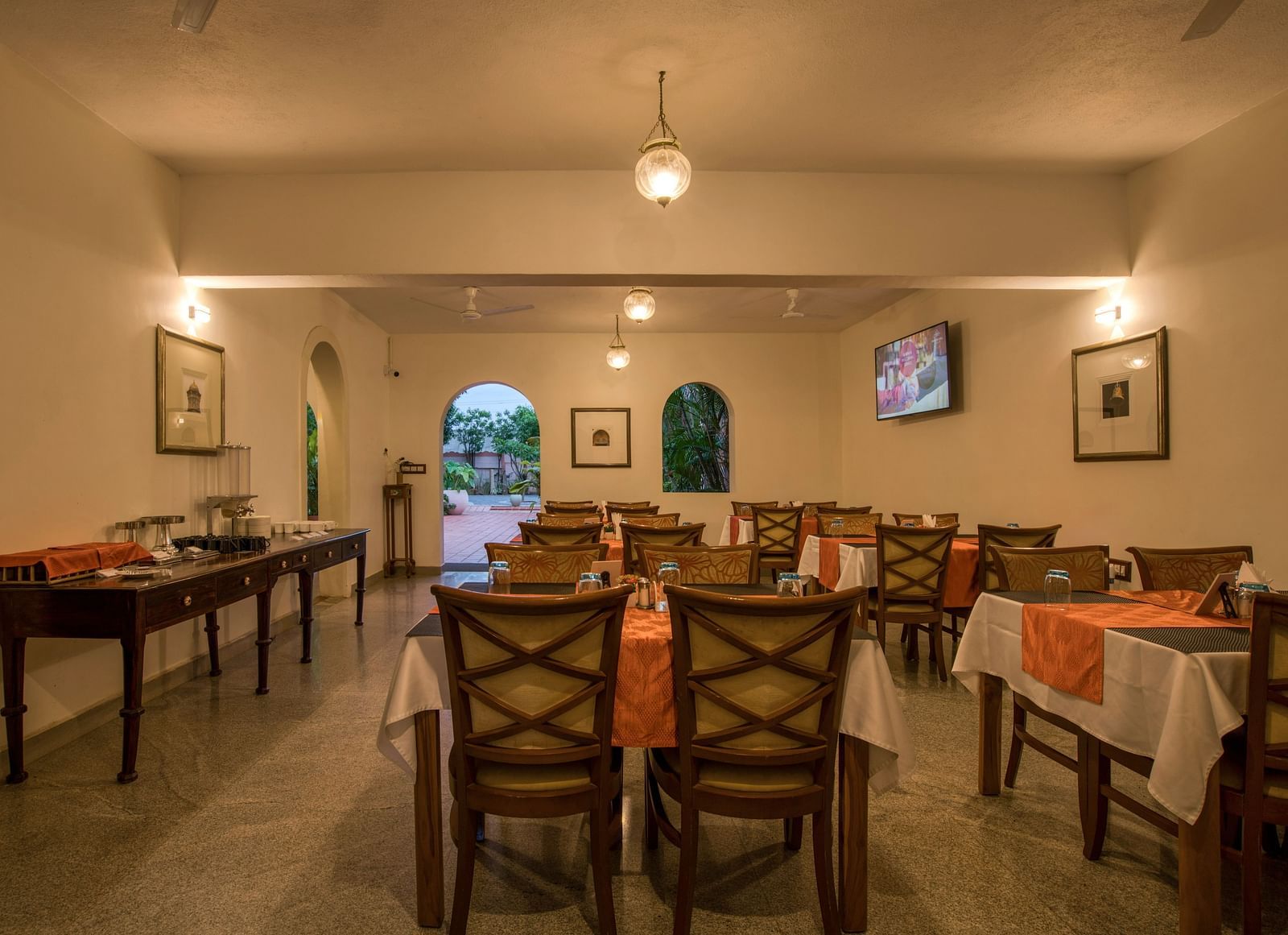 Back view of dinning space at a restaurant with chairs and tables.