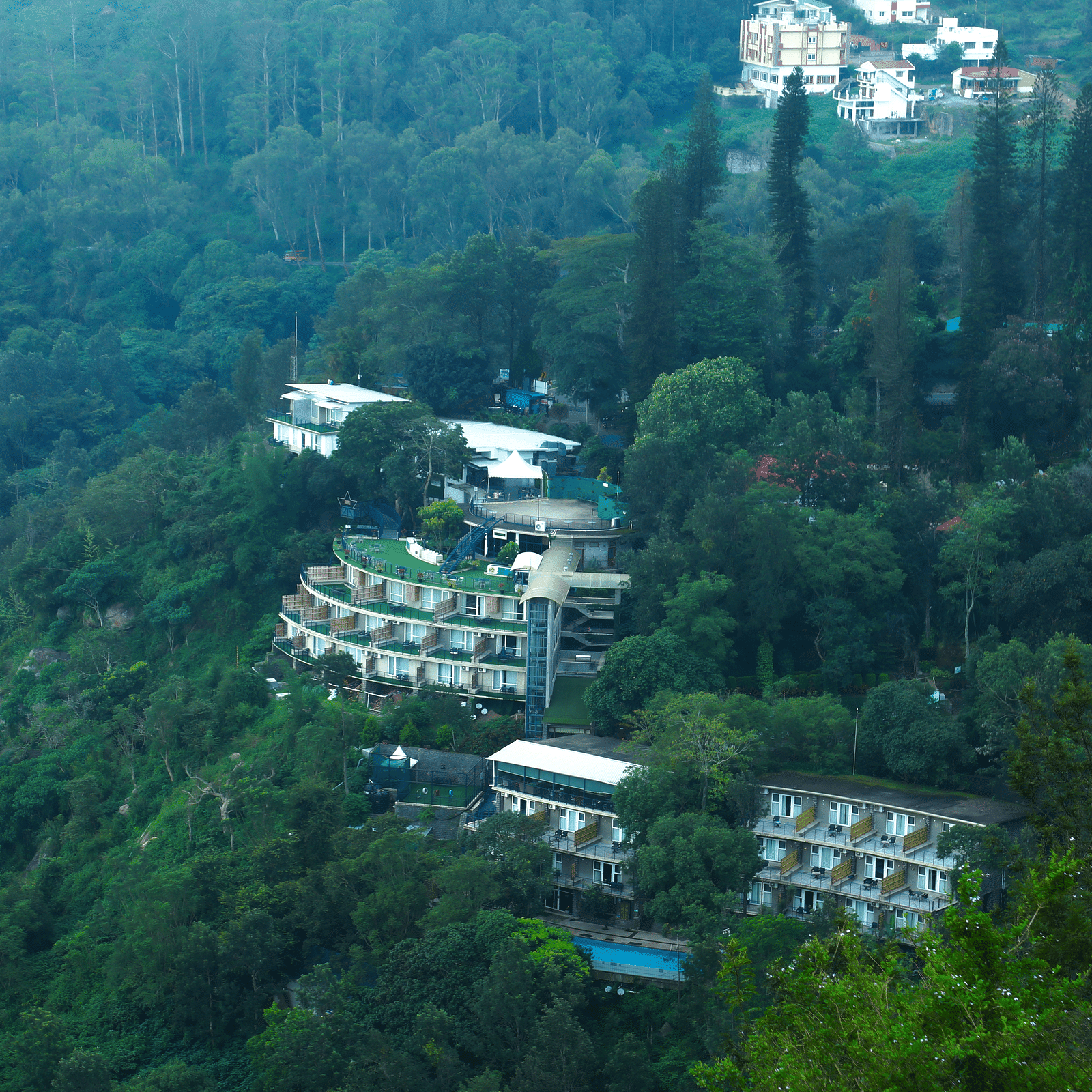 Drone shot of the hotel surrounded by the mountains and lush greenery - Great Trails Yercaud by GRT Hotels