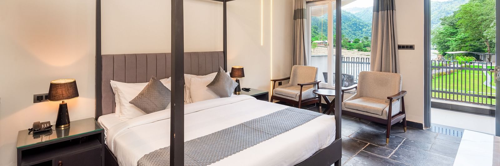Luxury Cottage at DLS Divine Resort and Spa featuring a bed, chairs and a private balcony with garden views. 