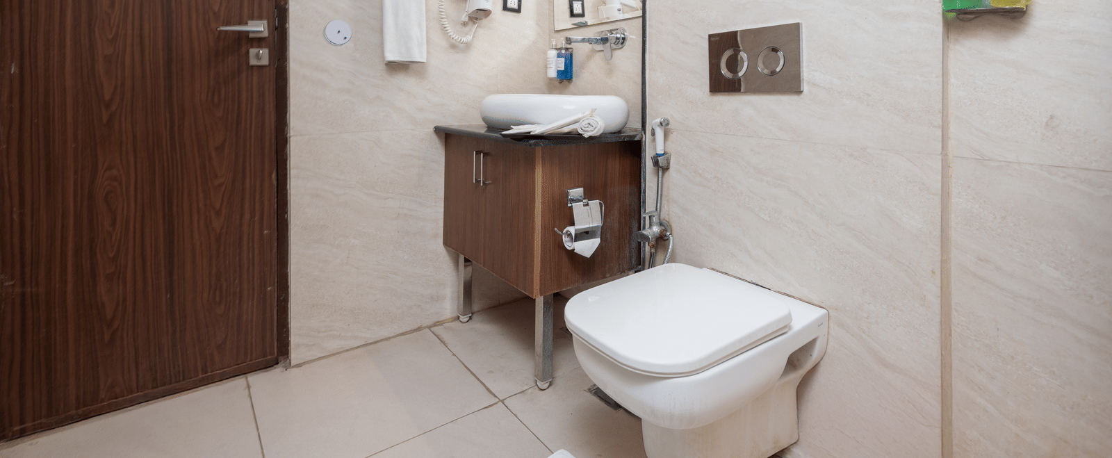 Bathroom with toilet, sink, and mirror at DLS Hotels On The Ganges.