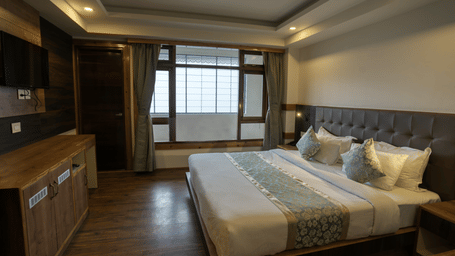 Image of the executive room with balcony with a expansive window and TV at our hotel I Avianna Gangtok Prime Hotel & Spa