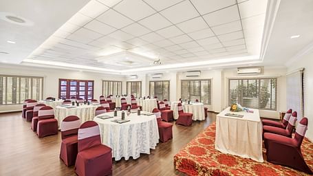 An image of the Mahasabha event hall with seating arrangement with bright lights - GReaT Trails River View Resort Thanjavur By GRT Hotels