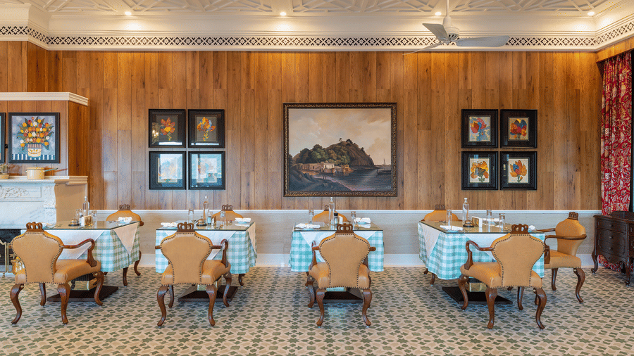 Elegantly laid dining tables in a wood-panelled room at Mayfair Manor, Jungpana.