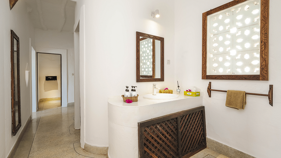 View of vanity with a mirror, sink, towel and window on the side in Sea View Family Cottages - Shooting Star Boutique Hotel.