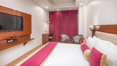 Spacious bedroom with double bed and TV at DLS Hotels On The Ganges.