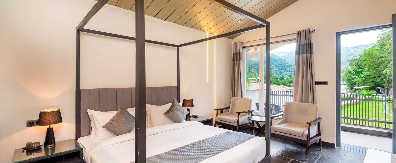 Luxury Cottage at DLS Divine Resort and Spa featuring a bed, chairs and a private balcony with garden views. 