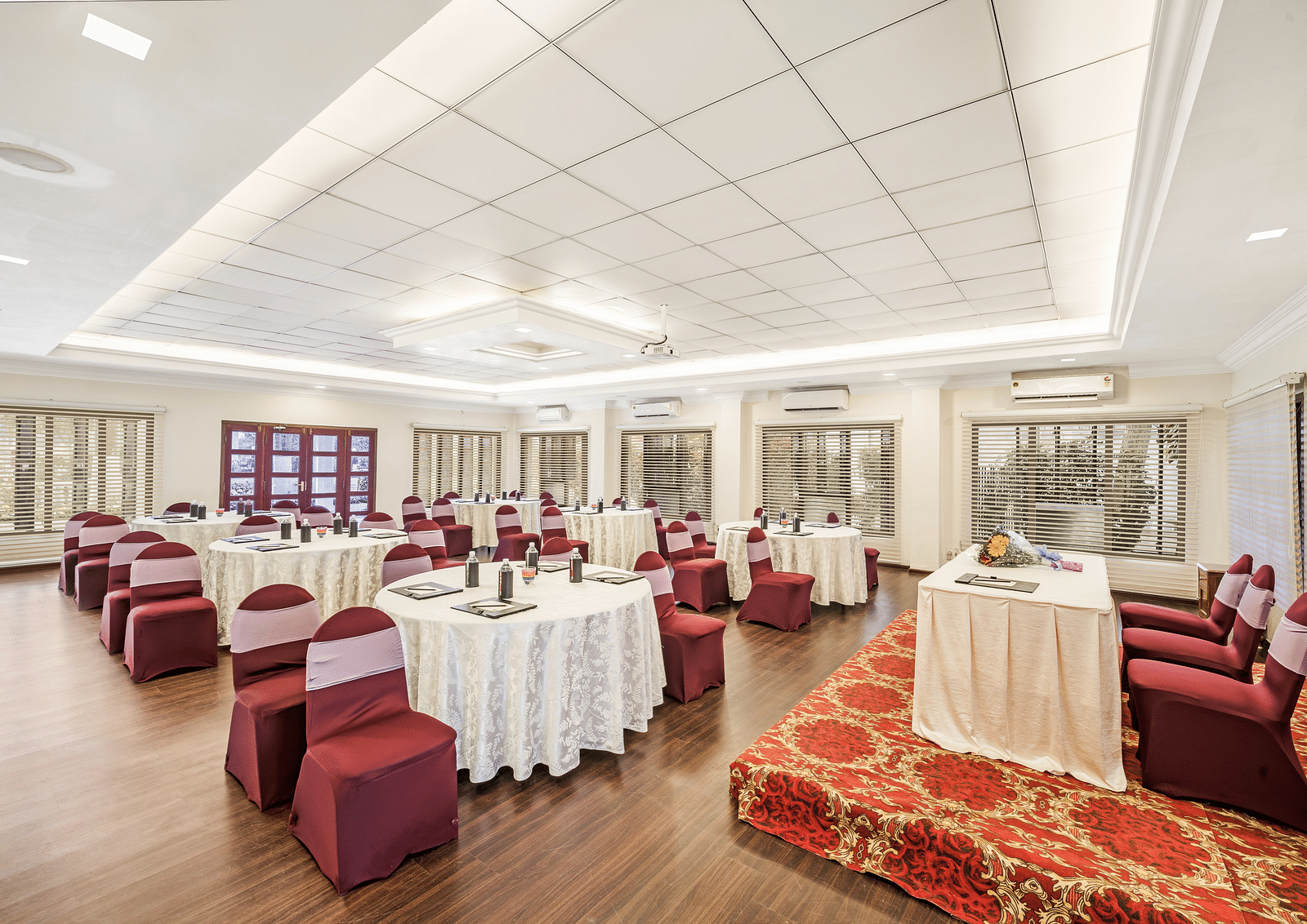 An image of the Mahasabha event hall with seating arrangement with bright lights - GReaT Trails River View Resort Thanjavur By GRT Hotels