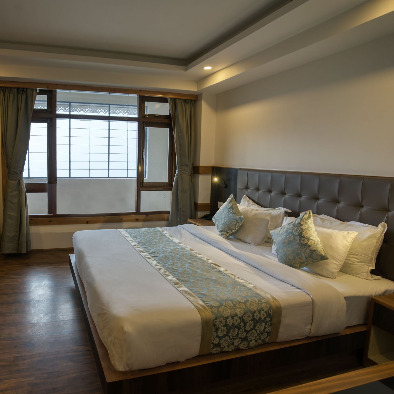 Image of the executive room with balcony with a expansive window and TV at our hotel I Avianna Gangtok Prime Hotel & Spa