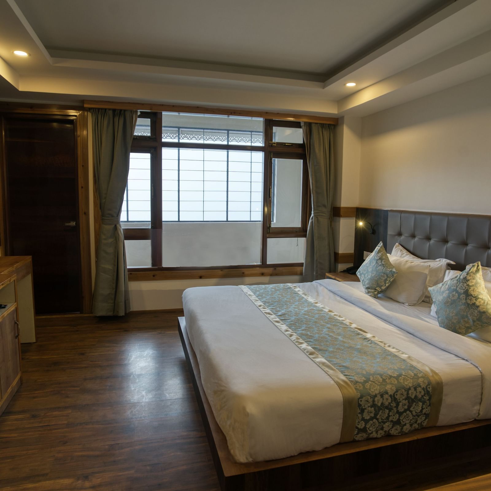 Image of the executive room with balcony with a expansive window and TV at our hotel I Avianna Gangtok Prime Hotel & Spa