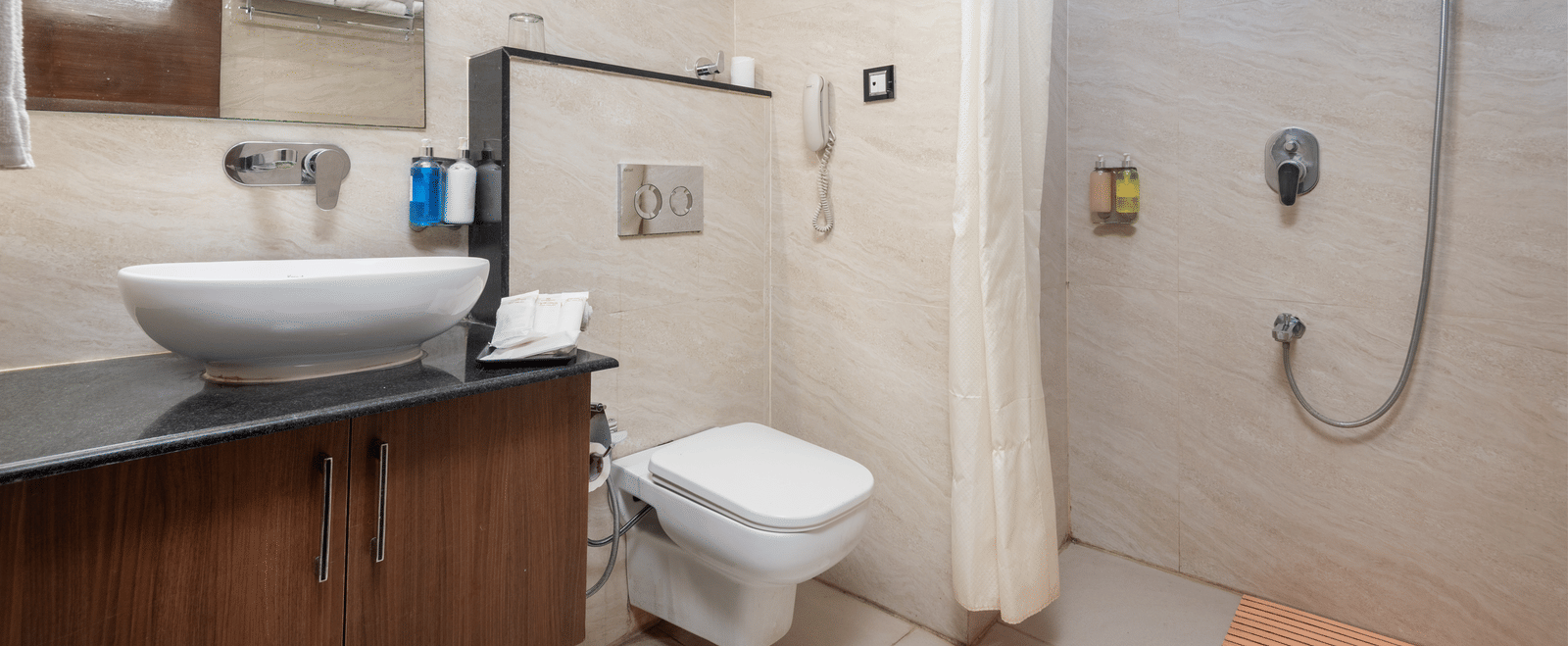 Bathroom with shower, toilet, and washbasin at DLS Hotels On The Ganges.