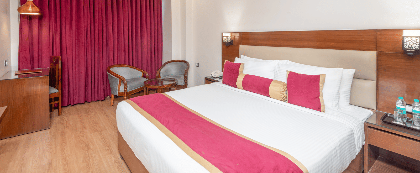 Bedroom with double bed and pink curtains at DLS Hotels On The Ganges.