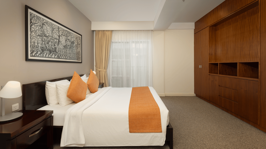Penthouse bedroom at Central Mansions, Phnom Penh with a king bed, built in wardrobe, and spacious interiors.