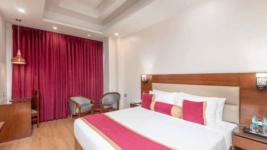Bedroom with double bed and pink curtains at DLS Hotels On The Ganges.