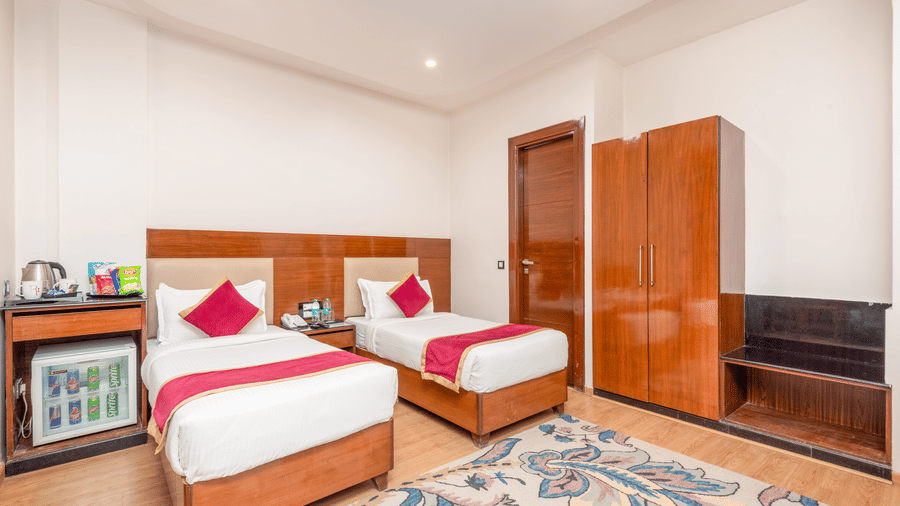 Twin bed room with wardrobe and seating at DLS Hotels On The Ganges.