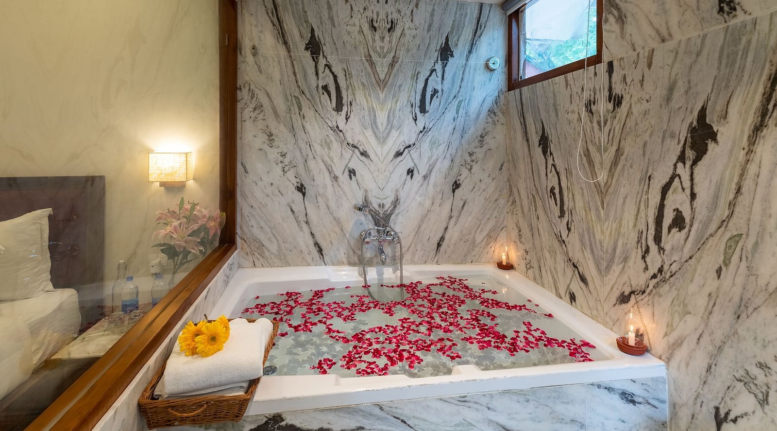 an image featuring a full size bathtub with rose petals floating on the bathtub at the the luxury suite villa at aranya vilas