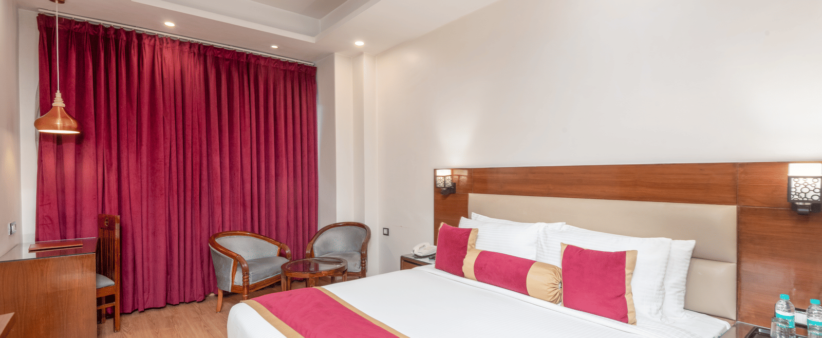 Bedroom with double bed and pink curtains at DLS Hotels On The Ganges.