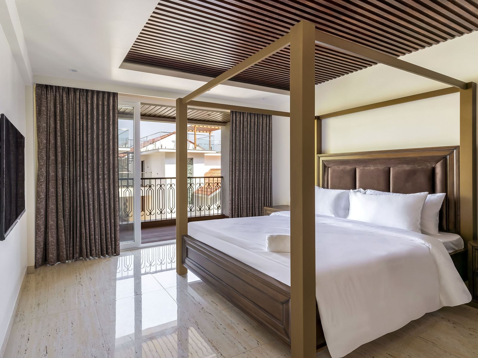 A double bed with wooden beams inside one of the rooms - The Tanisi Hotels & Resorts, Goa