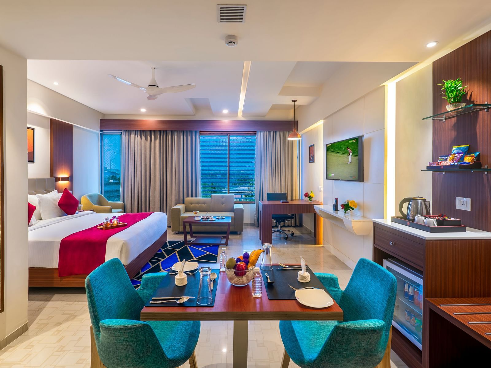 A hotel room with a bed featuring bedding, a television, and a desk area.