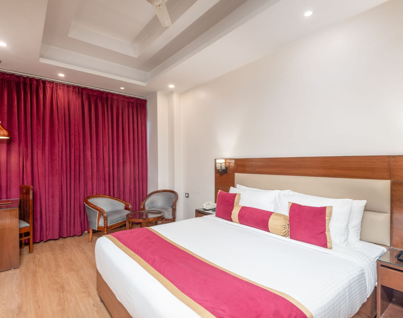 Bedroom with double bed and pink curtains at DLS Hotels On The Ganges.