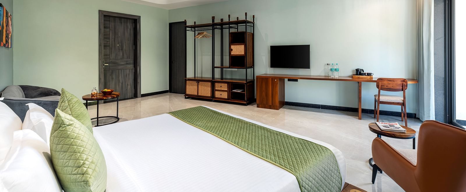 Club Suite with Valley View Sitout furnished with a king size bed, a television, and wooden furniture, presenting a comfortable and stylish interior at The Qualia Resort Club & Brewery, Udaipur.