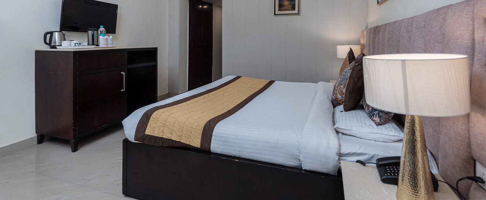 A side angle shot of the king size bed in the room that also features a television cabinet | DLS The Pearl