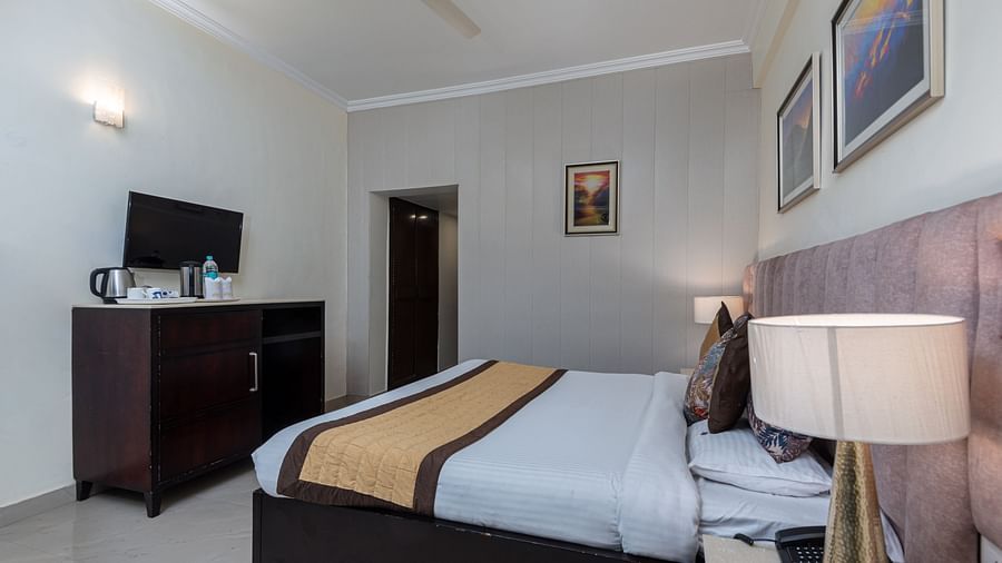 A side angle shot of the king size bed in the room that also features a television cabinet | DLS The Pearl