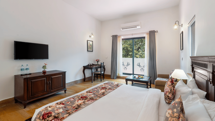 An overhead shot of overlooking the double bed facing the wall-mounted television at The Hunting Lodge, Udaipur.