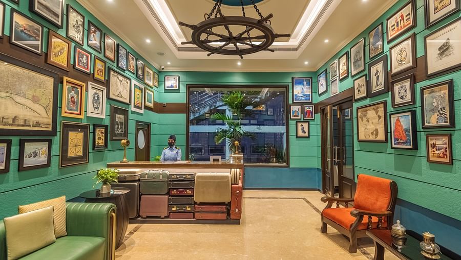 the reception area with seats on either side and wall hangings - polo floatel kolkata