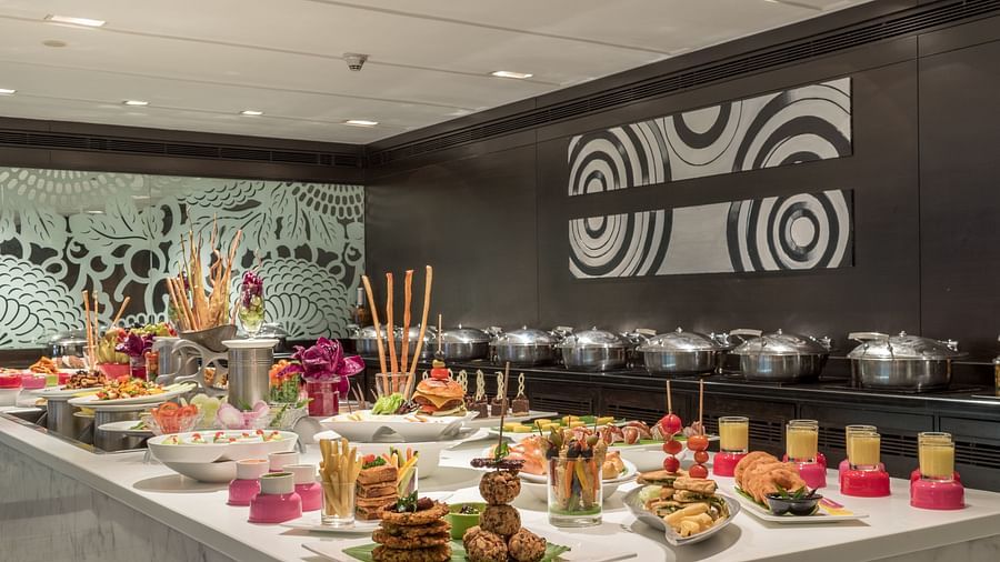 Lavish buffet setup with various plated dishes, desserts, and decorative elements in a restaurant setting.