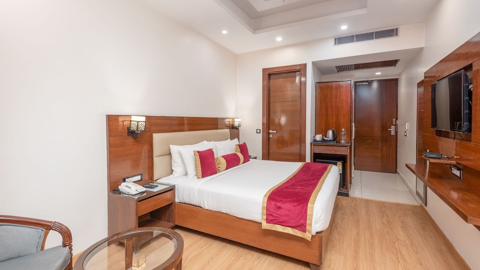 Spacious bedroom with double bed and seating at Regenta Inn DLS, Rishikesh.