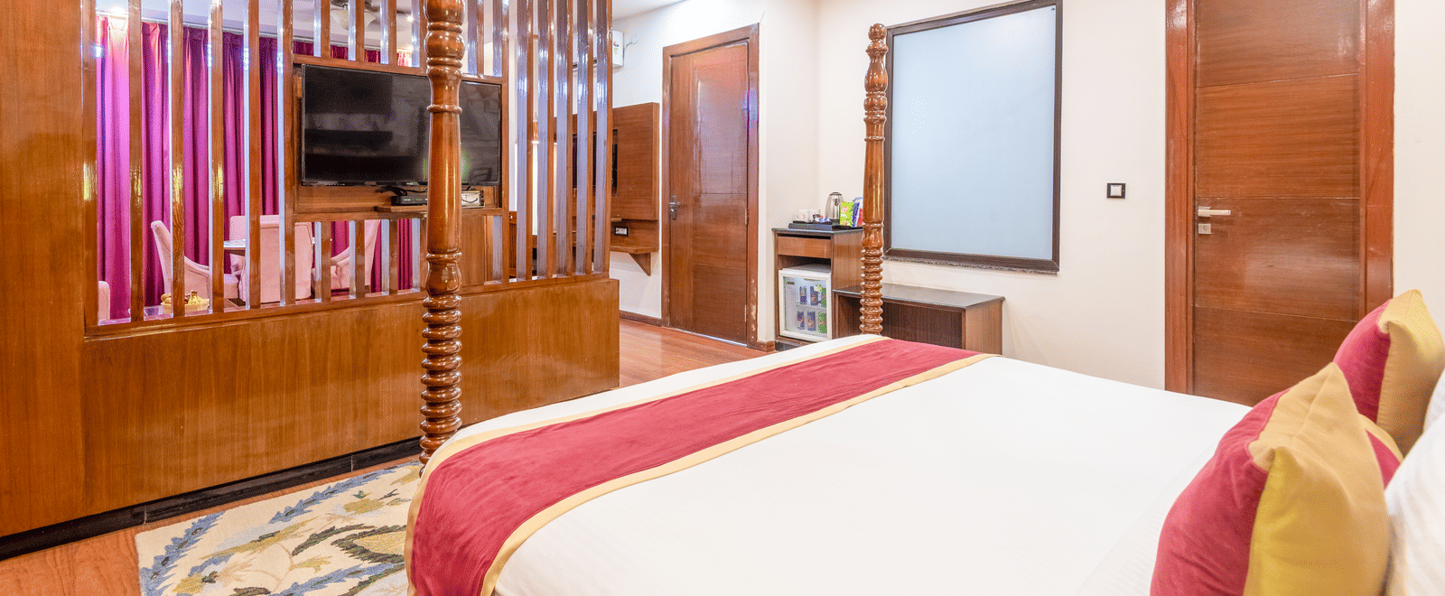 Bedroom with wooden flooring and partition wall at DLS Hotels On The Ganges.