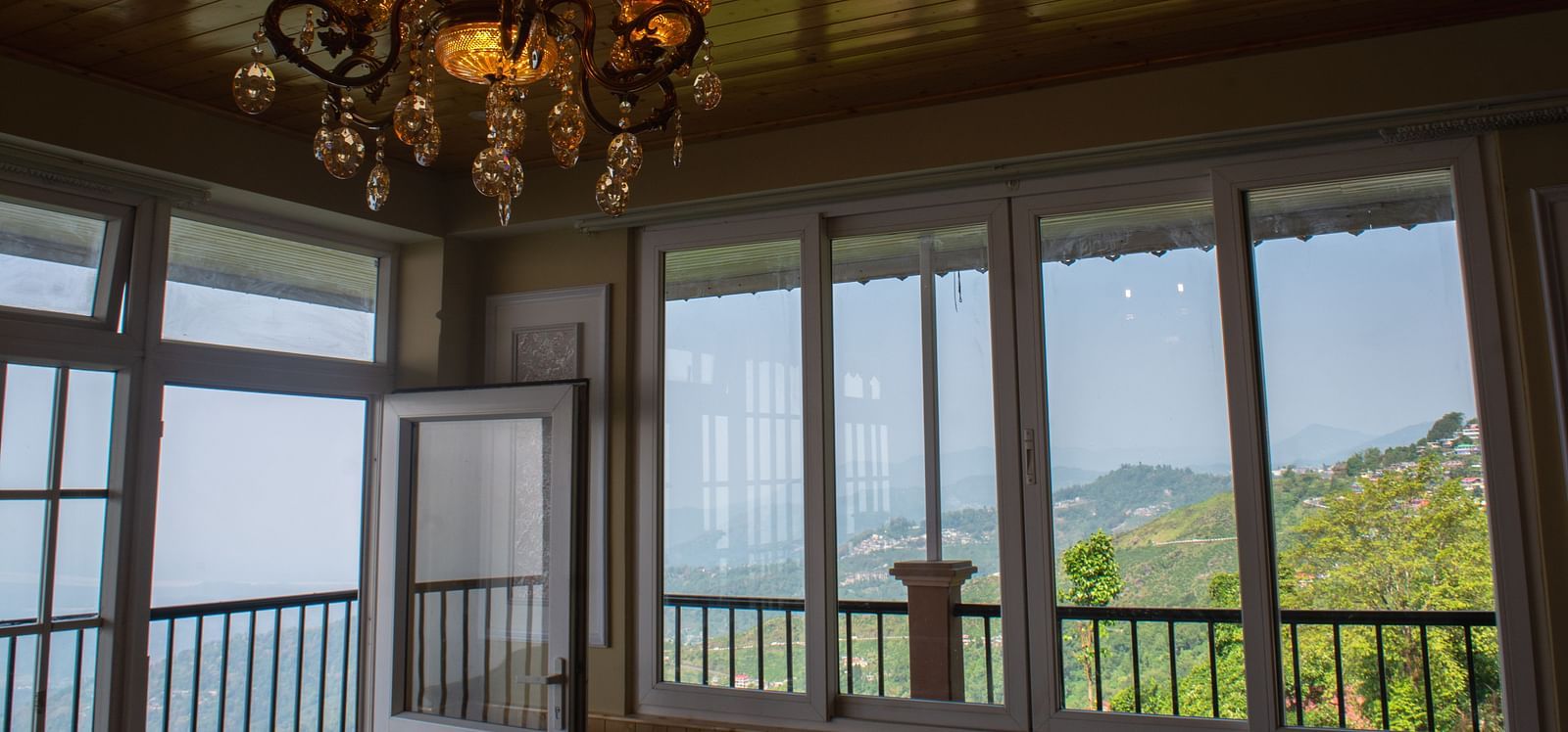 An imaging of a room with a chandelier hanging over viewing the mountains  - Avianna Windy House Wellness Retreat & Spa