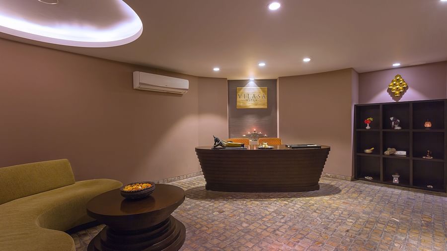 A modern lobby with a reception desk, comfortable seating, and decorative lighting.