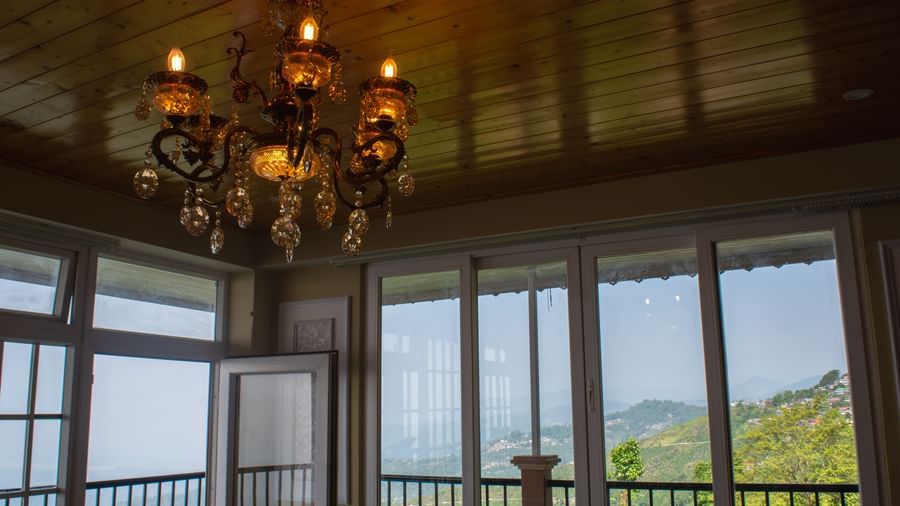 An imaging of a room with a chandelier hanging over viewing the mountains  - Avianna Windy House Wellness Retreat & Spa