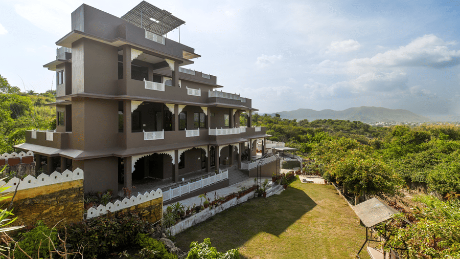 A large hillside mansion with arched balconies overlooks rolling green fields and scenic valleys.