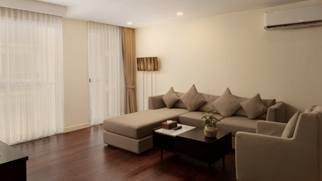 Living room in the Three Bedroom Family Suite at Central Mansions, Phnom Penh featuring a sofa set, coffee table, and spacious seating area.