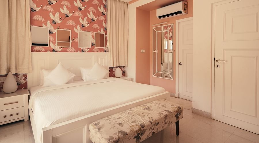 Cozy bedroom with pink floral wallpaper and elegant decor at Three BHK Premium Villa, Richmonde Ananta Elite, Goa.