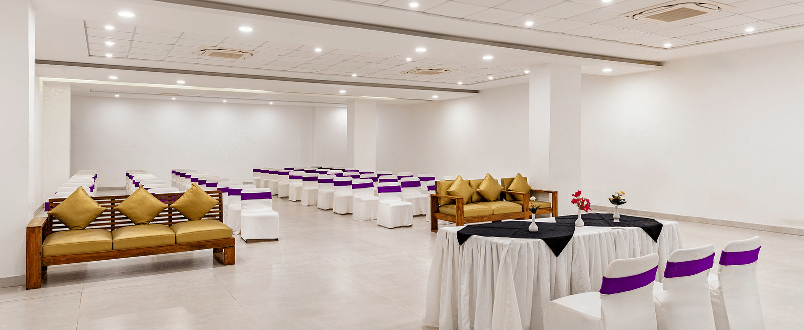 A event hall with white tables, chairs and couches in golden colour - Via Lakhela Resort & Spa