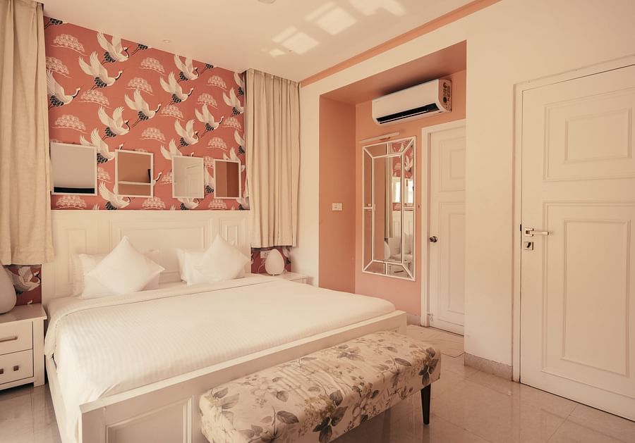 Cozy bedroom with pink floral wallpaper and elegant decor at Three BHK Premium Villa, Richmonde Ananta Elite, Goa.