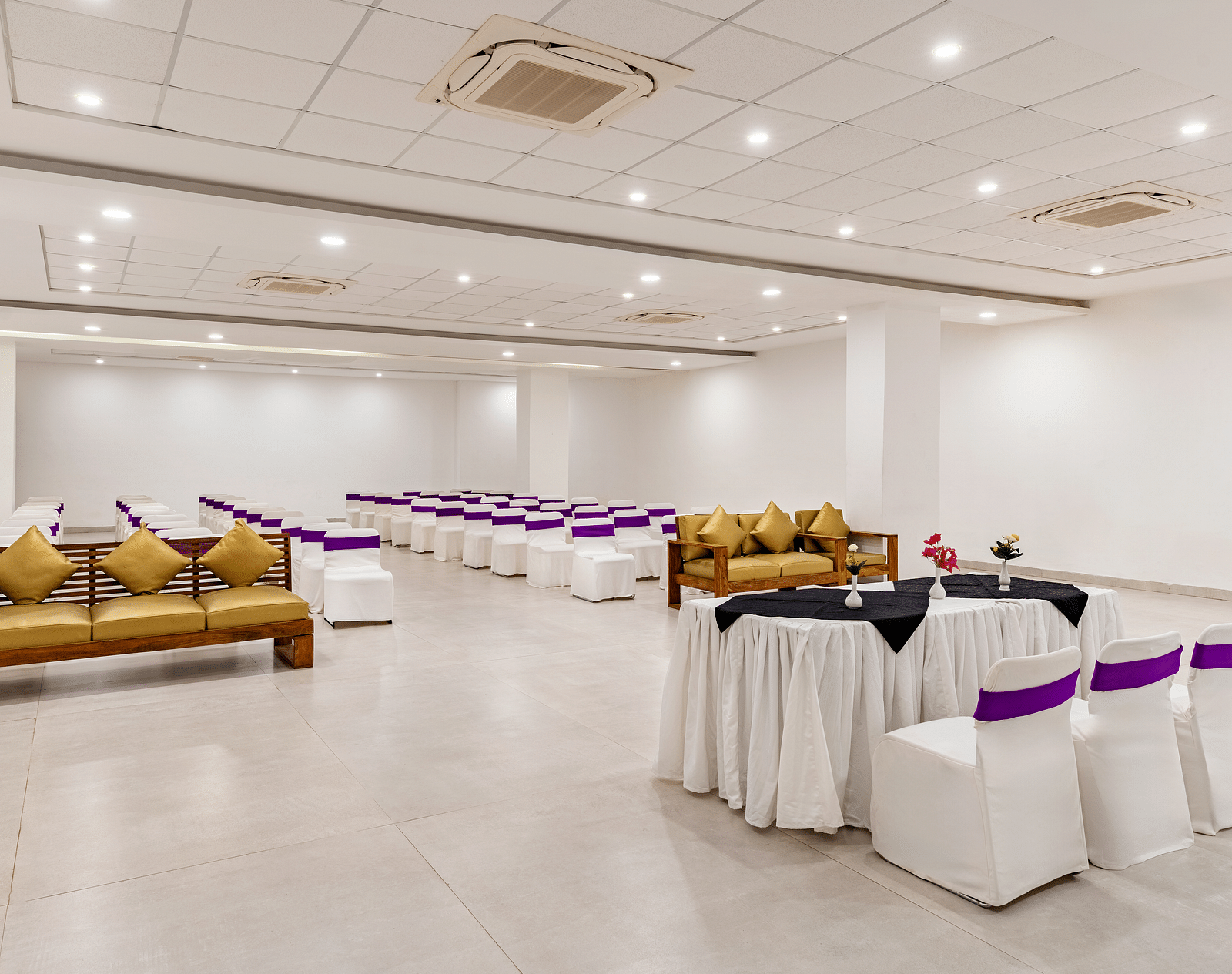 A event hall with white tables, chairs and couches in golden colour - Via Lakhela Resort & Spa