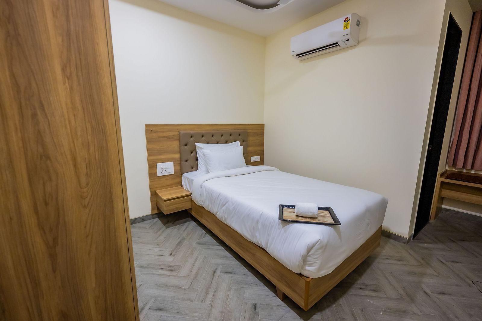 A cosy hotel room featuring a wooden bed and minimal decor at Lotus Leaf Boutique Hotel.