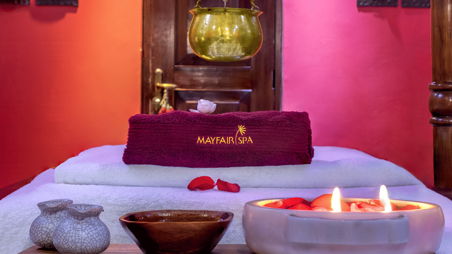 Serene spa setup with candles, flower petals and traditional decor at Mayfair Lagoon Bhubaneswar