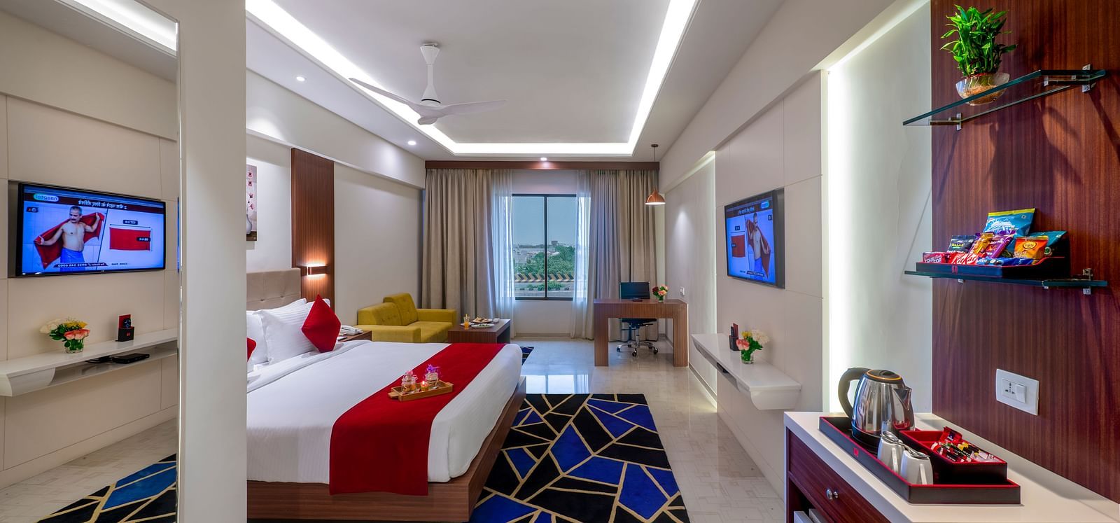 A hotel room with a bed featuring bedding, a television, and a seating area.
