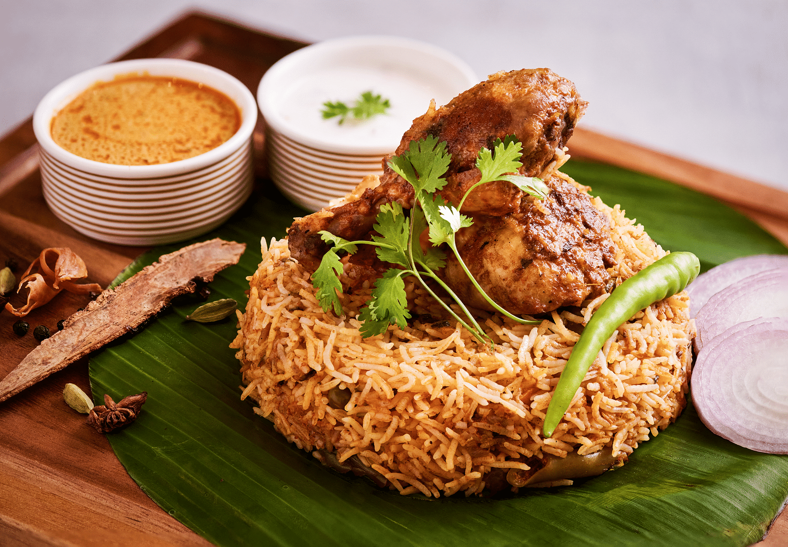 Biryani served on a leaf with curries placed alongside each other.