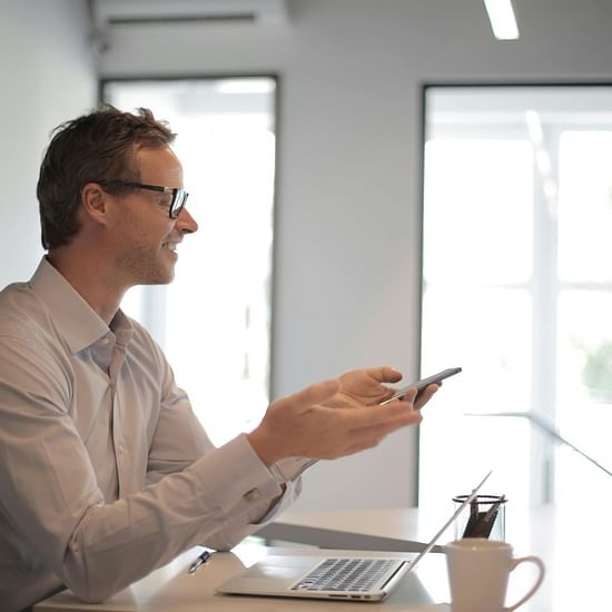 A person sitting near his desk and speaking